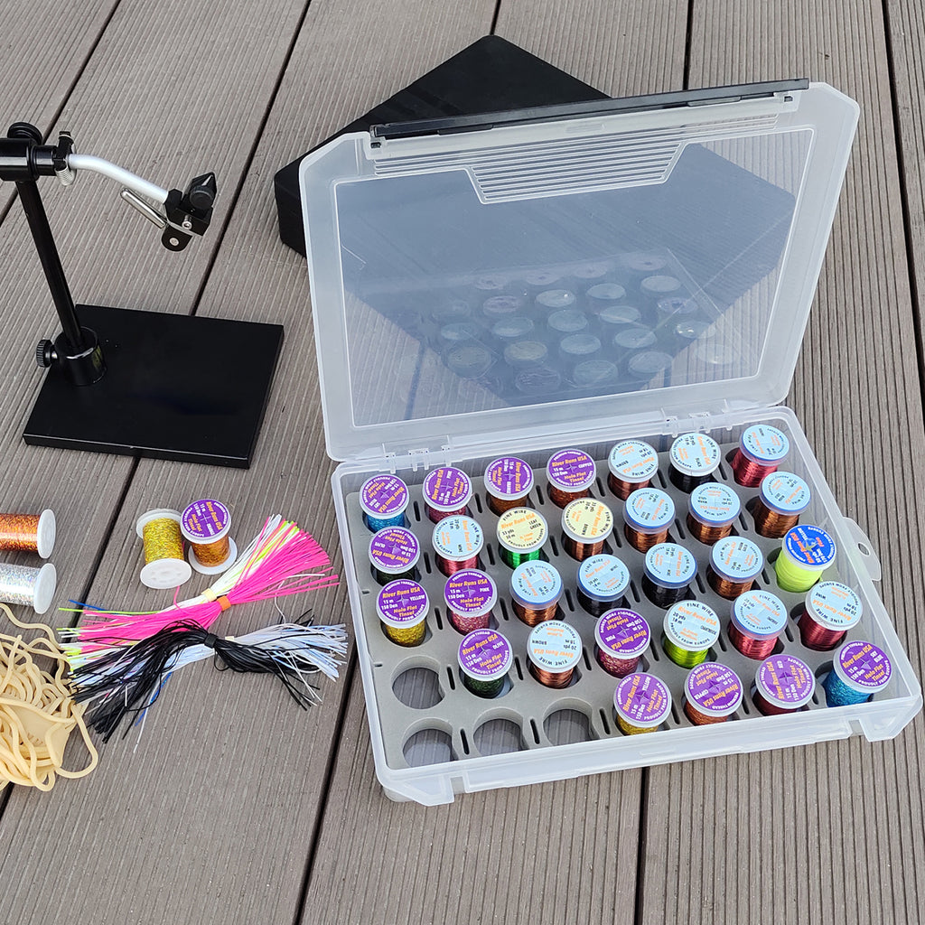 35-spool thread box open with colorful thread spools at a fly tying bench