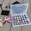 35-spool thread box open with colorful thread spools at a fly tying bench