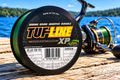TUF-LINE XP 65 lb green braided line spool on a dock by the lake